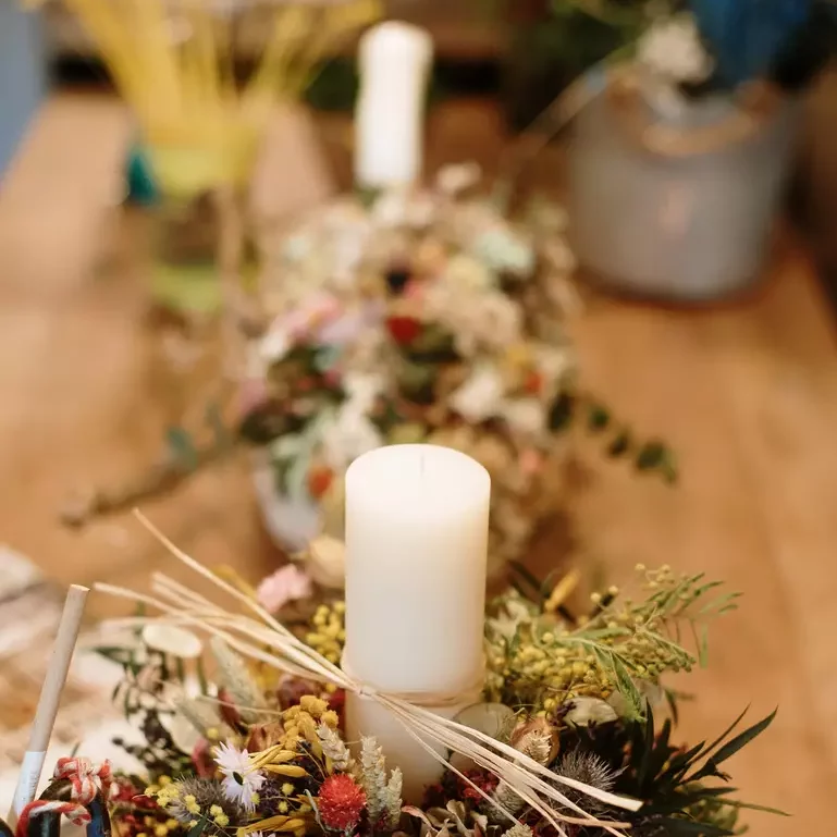 décoration de centre de table composée de bougie pilier et de fleurs séchées